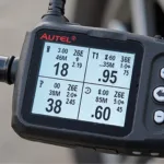 Close-up of an Autel TPMS scanner displaying tire pressure data