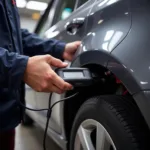 Mechanic Using OBD2 Scanner on Car