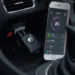 OBD2 tracker plugged into a car's OBD2 port and connected to a smartphone via Bluetooth, displaying real-time vehicle data.